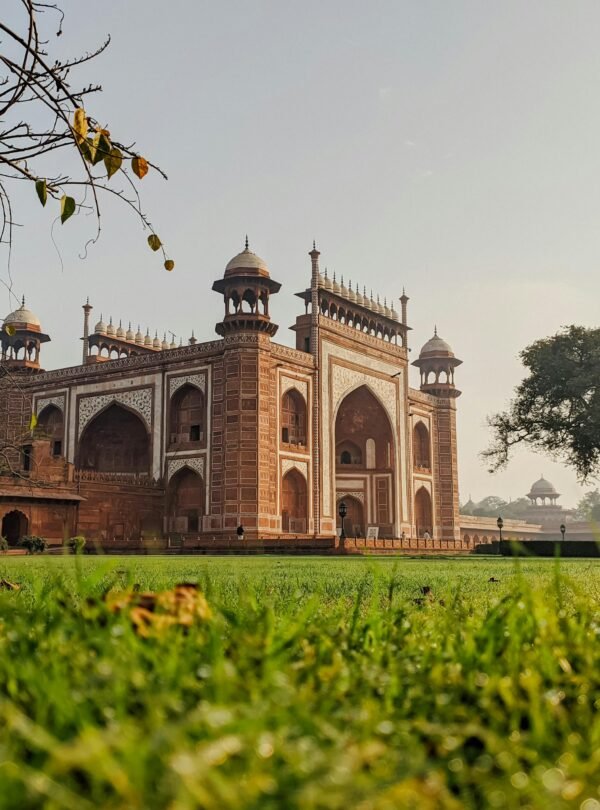 Stunning view of Mughal architecture with lush green surroundings at sunrise.