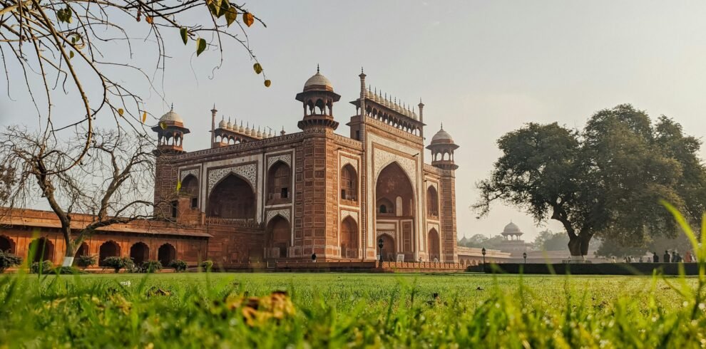 Stunning view of Mughal architecture with lush green surroundings at sunrise.