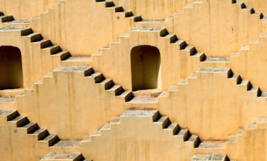 Intricate symmetrical steps of a Jaipur stepwell showcasing ancient architectural design.